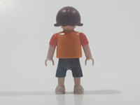 2010 Geobra Playmobil Small Brunette Girl Child Dark Grey Capri Pants Two Tone Orange Shirt with Lizard Design 2 1/8" Tall Toy Figure