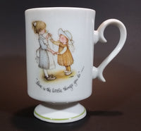 1973 Holly Hobbie Genuine Porcelain WWA "Love is the little things you do" Girls Smelling Flowers Pedestal Mug Cup - Treasure Valley Antiques & Collectibles