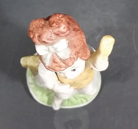 Vintage Victorian Girl Sitting on a Fence Playing a Mandolin Ceramic Figurine - Treasure Valley Antiques & Collectibles