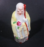 Vintage Chinese God Shou Wiseman in a Yellow Robe with Red Staff holding Fruit Ceramic Figurine - Treasure Valley Antiques & Collectibles
