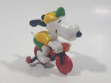 Vintage United Feature Peanuts Snoopy Learning To Ride A Bike On Bicycle With Training Wheels 2 1/2" Tall PVC Toy Figure Made in Hong Kong