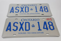 Matching Set of 2 Ontario Yours To Discover White with Blue Letters Vehicle License Plate ASXD 148