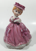 Vintage Girl in Pink Dress with Bows Wearing a Hat Holding Pen and Paper 7" Ceramic Wind Up Musical Figurine