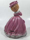 Vintage Girl in Pink Dress with Bows Wearing a Hat Holding Pen and Paper 7" Ceramic Wind Up Musical Figurine