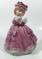 Vintage Girl in Pink Dress with Bows Wearing a Hat Holding Pen and Paper 7" Ceramic Wind Up Musical Figurine