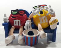 1999 M & M's Red And Yellow Character Sitting In Movie Theater Chairs Eating Popcorn Wearing 3D Glasses Plastic Candy Dispenser Machine