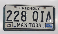 1997 Friendly Manitoba White With Black Letters Metal Vehicle License Plate Tag 228 QIA in Blue Cluthe Frame Holder